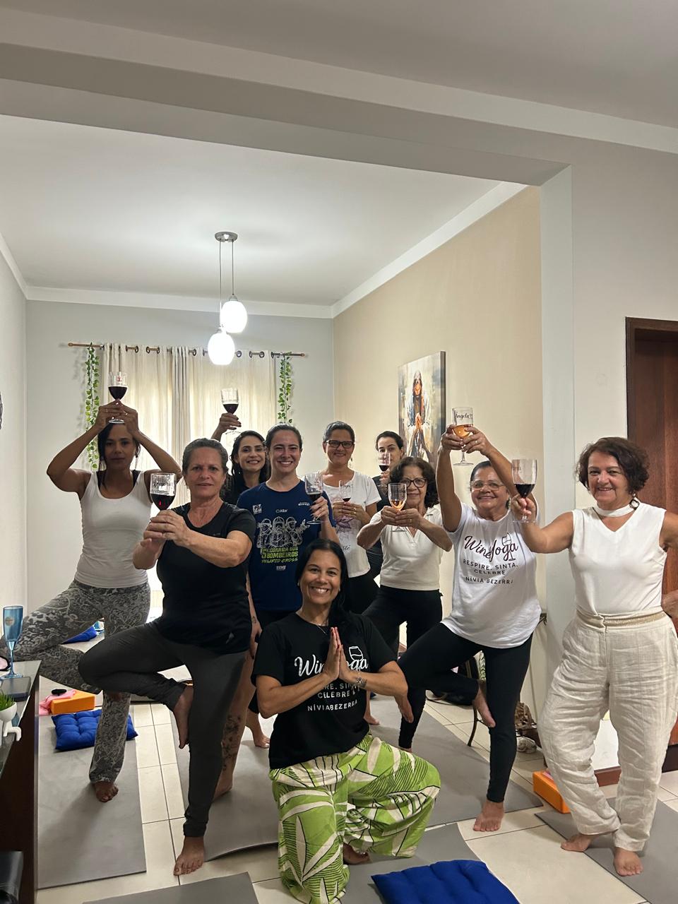 Turma celebrando em pose da árvore com taças